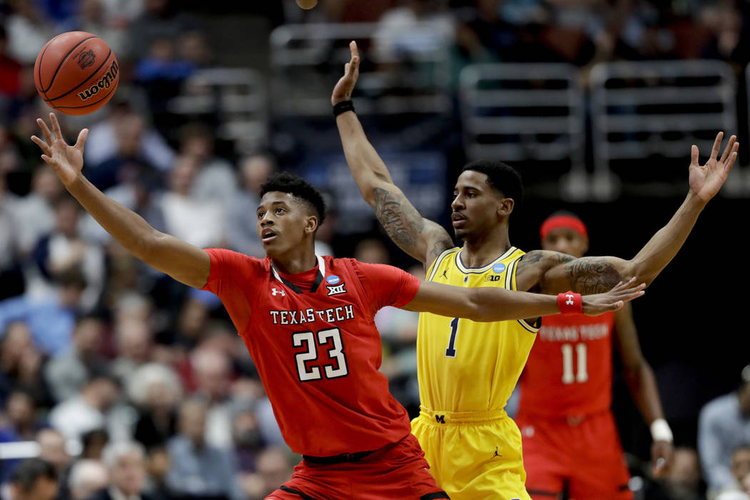 Texas Tech guard Jarrett Culver reaches for a pass as Michigan guard Charles Matthews defends d ...