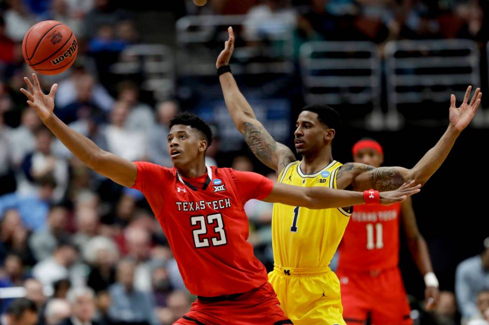 Texas Tech guard Jarrett Culver reaches for a pass as Michigan guard Charles Matthews defends d ...