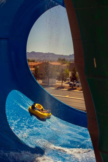 Riders raft down the wall of the Big Surf slide during opening day for the season at Cowabunga ...