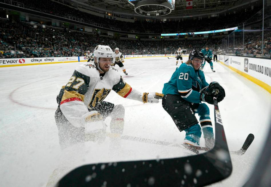 Vegas Golden Knights defenseman Shea Theodore (27) battles for the puck against San Jose Sharks ...