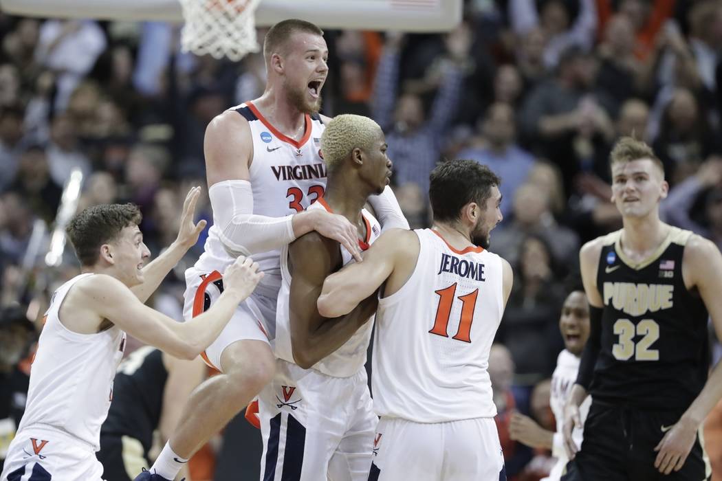 Virginia's Jack Salt (33) celebrates with teammates Mamadi Diakite and Ty Jerome (11) as Purdue ...