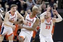 Virginia's Mamadi Diakite, center, reacts with teammates Kyle Guy and Jack Salt (33) after hitt ...