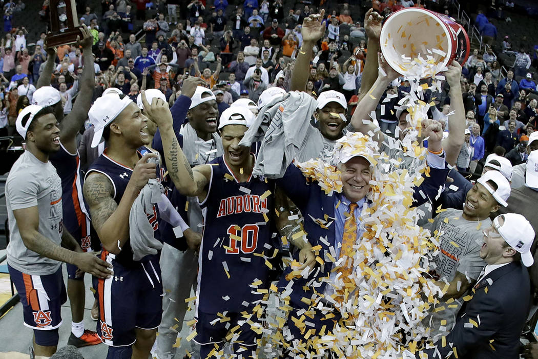 Auburn head coach Bruce Pearl is doused with confetti after the Midwest Regional final game aga ...