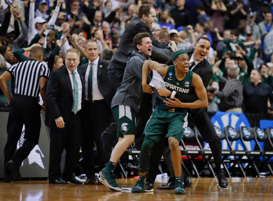 Michigan State guard Cassius Winston (5) begins to celebrate with members of his team after def ...