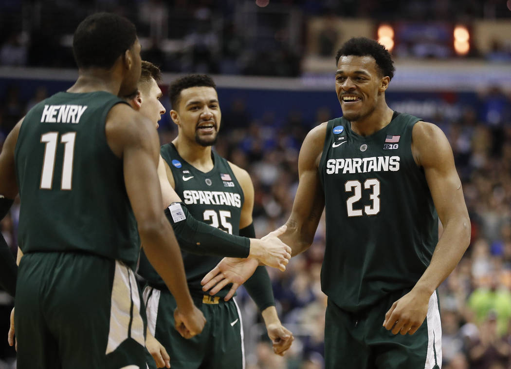 Michigan State forward Xavier Tillman (23) celebrates with teammates after scoring against Duke ...