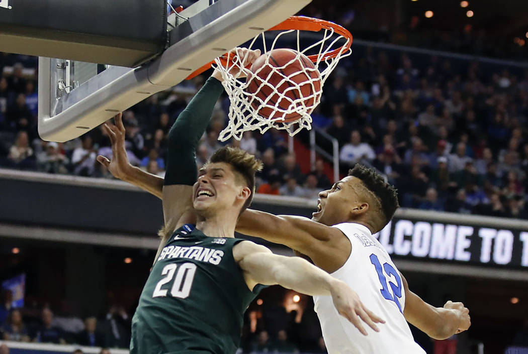 Michigan State guard Matt McQuaid (20) scores against Duke forward Javin DeLaurier (12) during ...