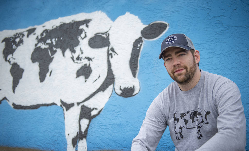 DJ Barry poses for a portrait in front of his mural located on the wall of Main Street Peddlers ...