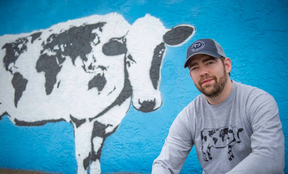 DJ Barry poses for a portrait in front of his mural located on the wall of Main Street Peddlers ...