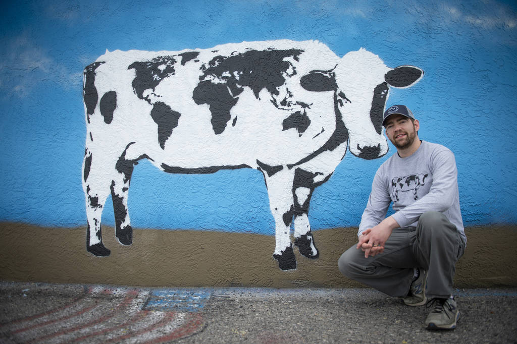 DJ Barry poses for a portrait in front of his mural located on the wall of Main Street Peddlers ...