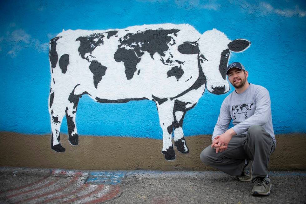 DJ Barry poses for a portrait in front of his mural located on the wall of Main Street Peddlers ...