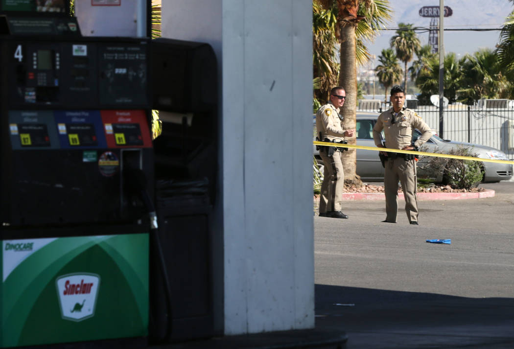 Las Vegas Metropolitan Police officers block off a gas station at the corner of Washington Aven ...