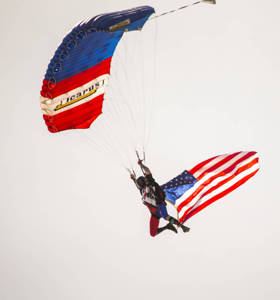 A parachuter arrives with the American flag during the NHRA Mello Yellow Drag Racing Series on ...