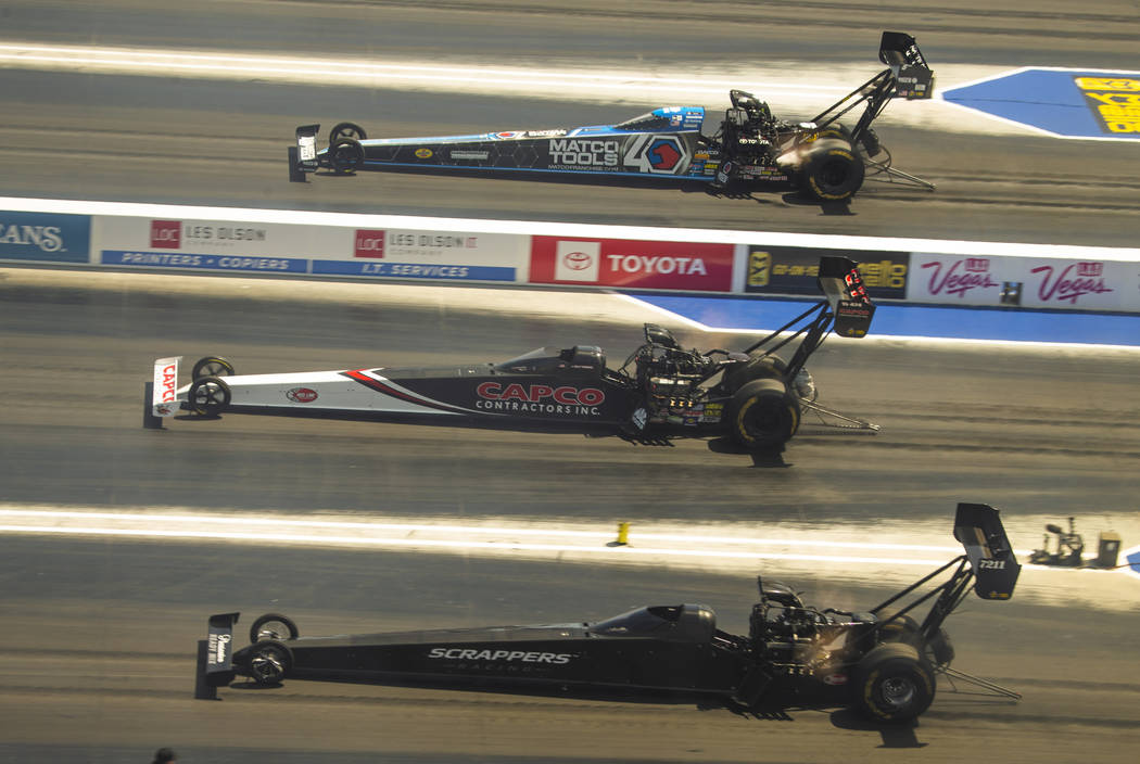 (From bottom) Top Fuel racers Mike Salinas, Billy Torrence and Antron Brown move down the track ...