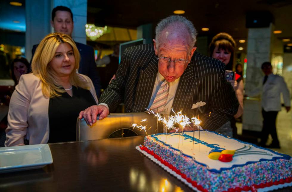 Former Las Vegas Mayor Oscar Goodman attempts to blow out some sparklers atop a congratulations ...