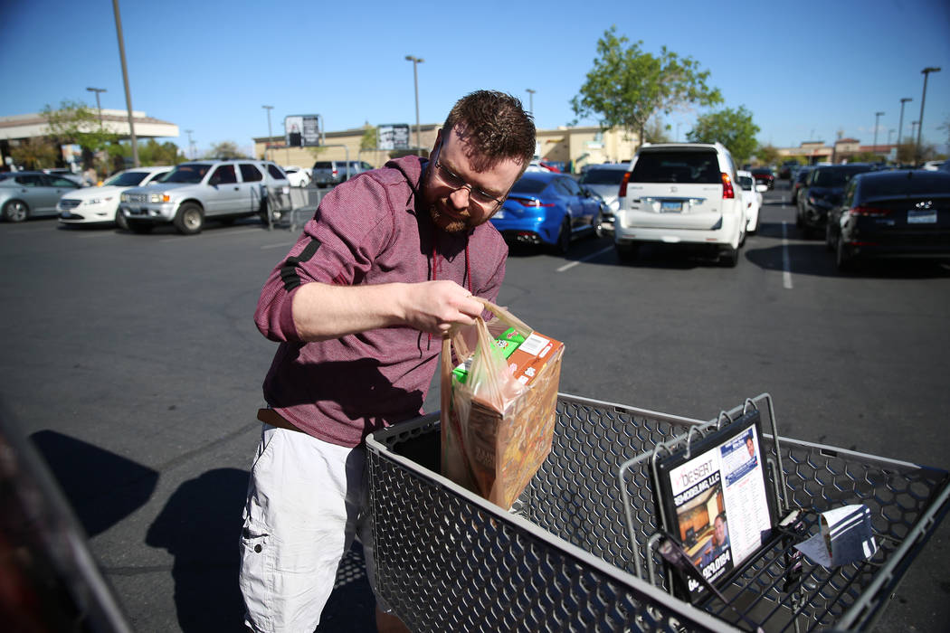 Mark Schoenfeldt of Las Vegas loads his car with groceries after shopping at Smith's, 10600 Sou ...