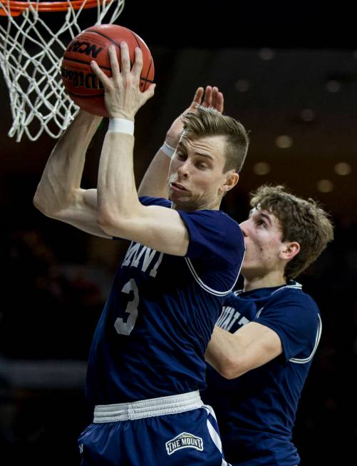 Mount St. Mary's Jonah Antonio (3) grabs a rebound in front of teammate Bobby Planutis during t ...