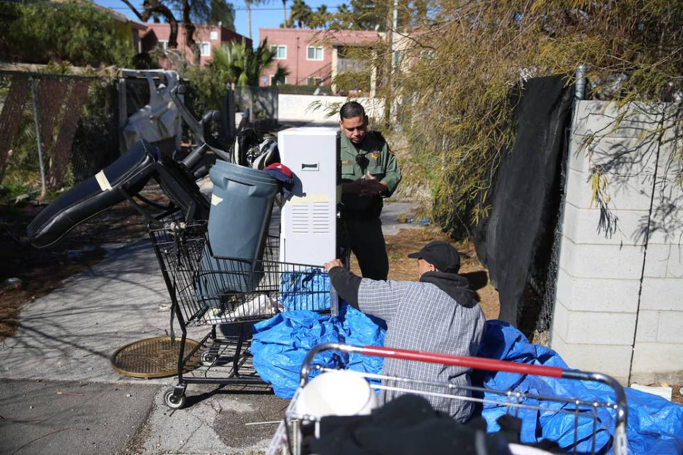 Las Vegas police officer Angel Nunez speaks with a homeless man on an alley near the intersecti ...