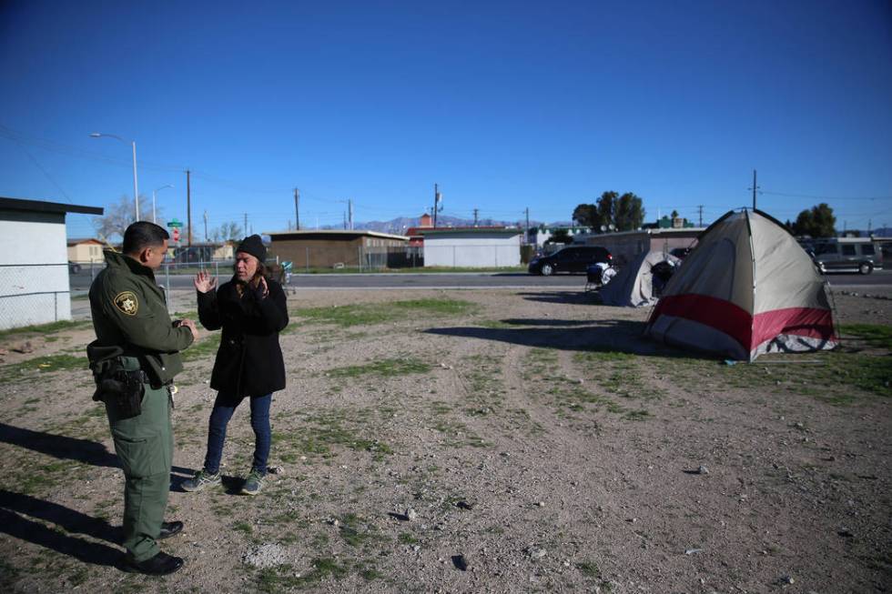 Las Vegas police officer Angel Nunez speaks with homeless man Charles Whritenour about services ...