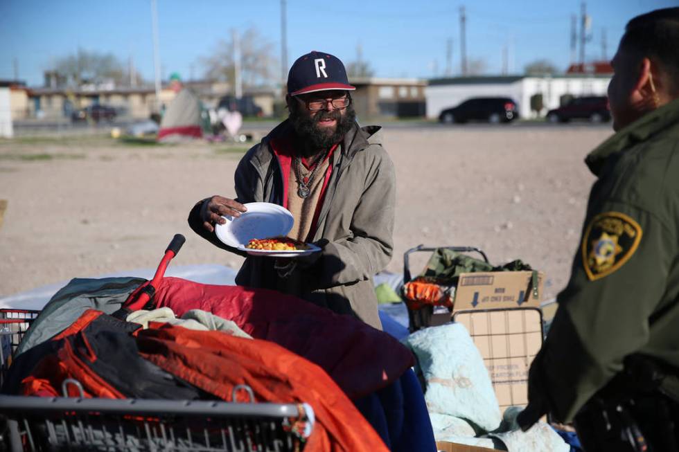 Homeless man Anthony Muratore talks to Las Vegas police officer Angel Nunez near the intersecti ...