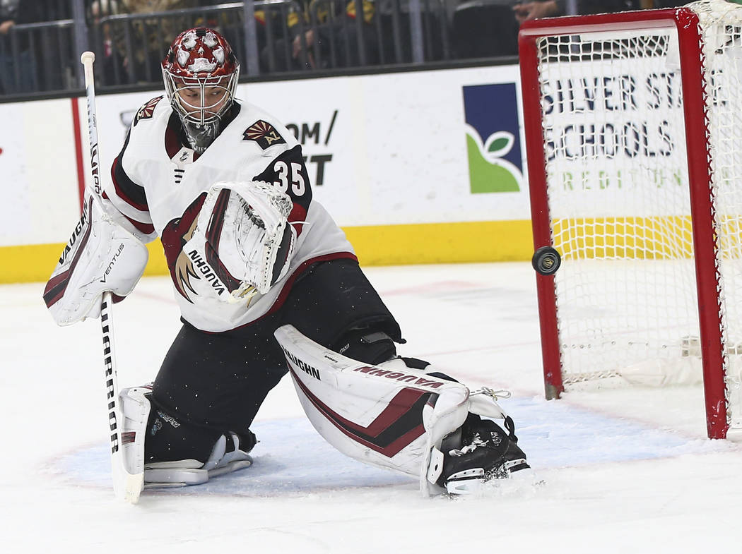 A shot flies by Arizona Coyotes goaltender Darcy Kuemper (35) during the first period of an NHL ...