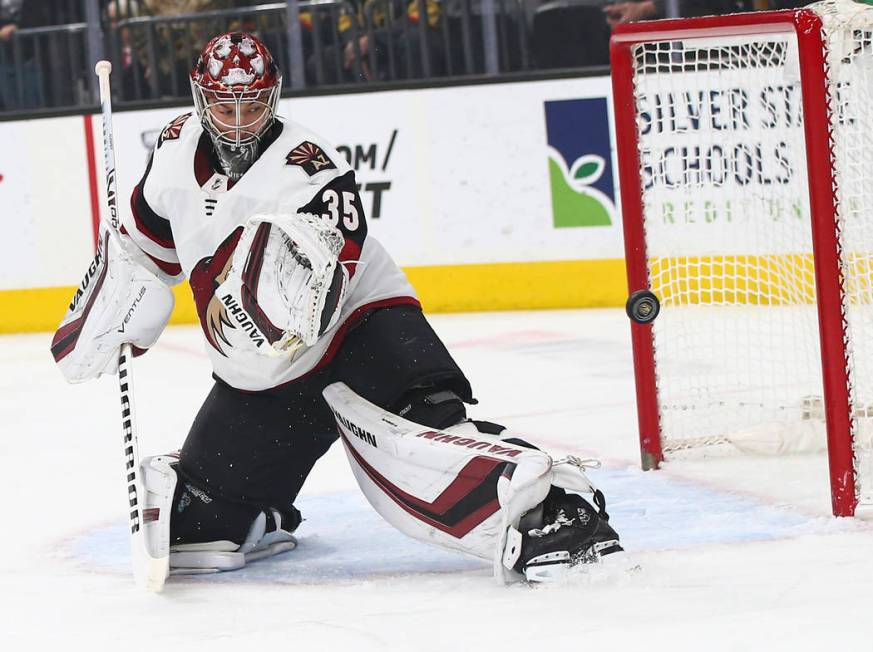 A shot flies by Arizona Coyotes goaltender Darcy Kuemper (35) during the first period of an NHL ...