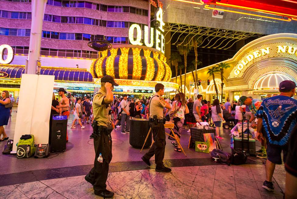 Security officers patrol along the Fremont Street Experience in downtown Las Vegas on Thursday, ...