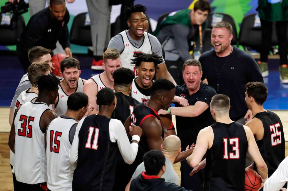 Texas Tech head coach Chris Beard laughs with his players in a huddle during a practice session ...