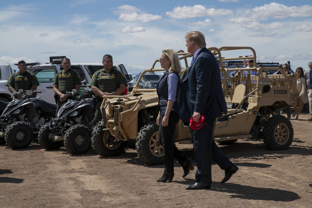 President Donald Trump walks with Homeland Security Secretary Kirstjen Nielsen as they visit a ...