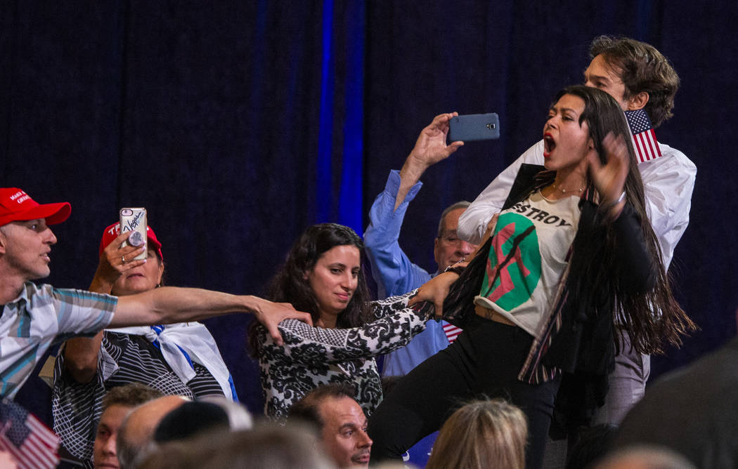 Protesters shout out as President Donald J. Trump addresses the Republican Jewish Coalition dur ...