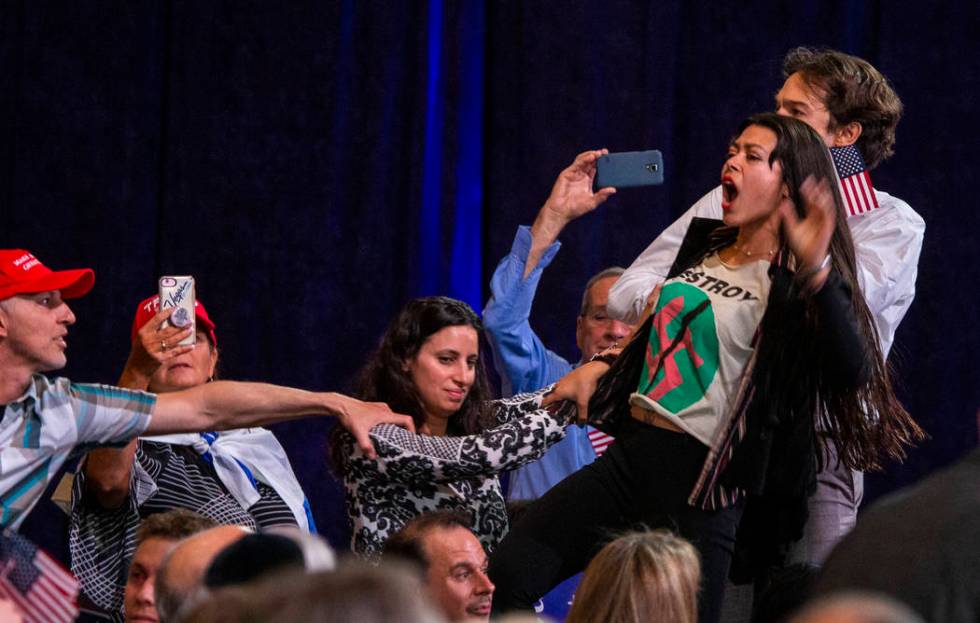 Protesters shout out as President Donald J. Trump addresses the Republican Jewish Coalition dur ...