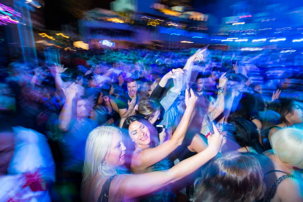 Attendees record with their phones as performers entertain by the outdoor stage during the gran ...