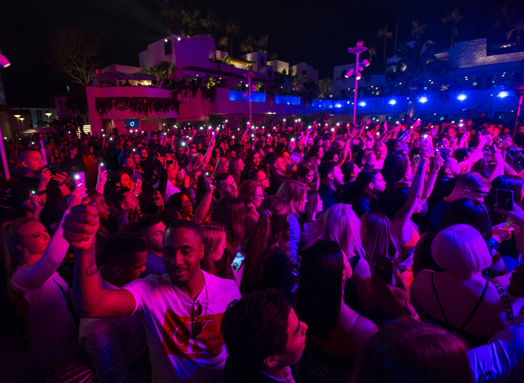 Attendees hold up phones and lighters in memory of Nipsey Hussle during the grand opening weeke ...