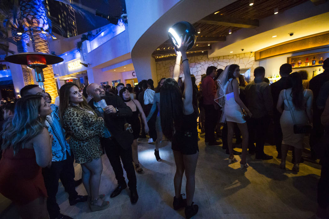 Karen Miranda holds up a hypno camera for attendees to take a picture with during the grand ope ...