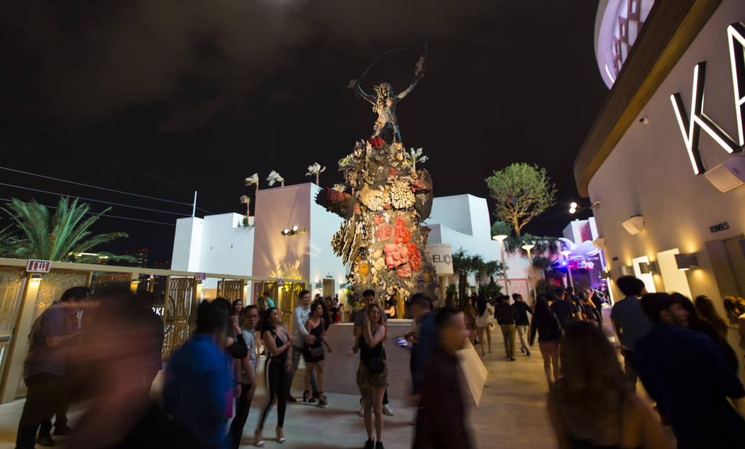 Attendees walk through the entrance by Damien Hirst's "Warrior and the Bear" scupture ...