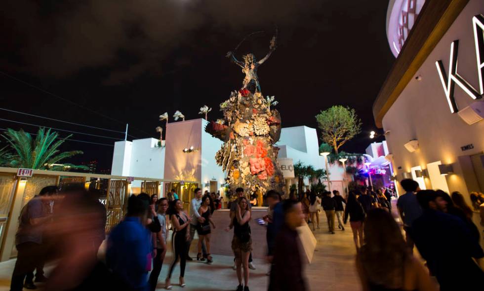 Attendees walk through the entrance by Damien Hirst's "Warrior and the Bear" scupture ...