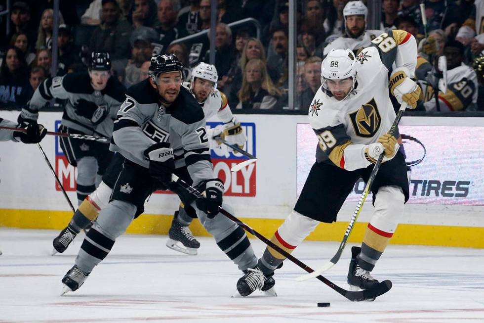 Los Angeles Kings defenseman Alec Martinez (27) vies with Vegas Golden Knights forward Alex Tuc ...