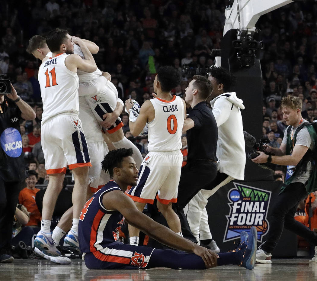 Auburn's Anfernee McLemore (24) reacts on the floor as Virginia celebrate after defeating Aubur ...