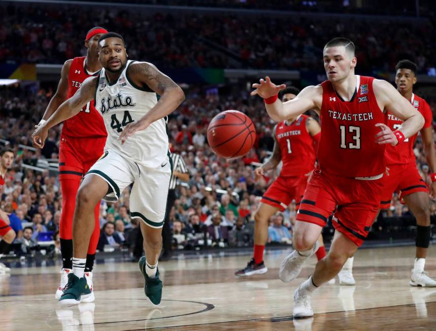 Texas Tech's Matt Mooney (13) chases a loose ball against Michigan State's Nick Ward (44) durin ...