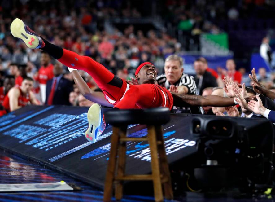 Texas Tech forward Tariq Owens lands on the scorers table while trying to save a ball from goin ...