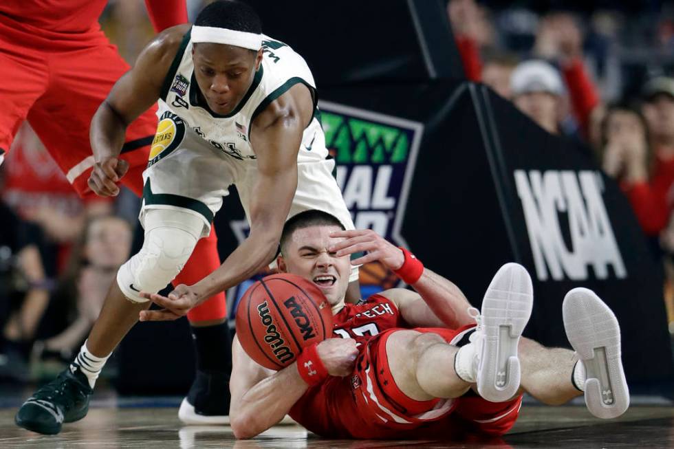 Texas Tech's Matt Mooney (13) battles for a loose ball against Michigan State's Cassius Winston ...