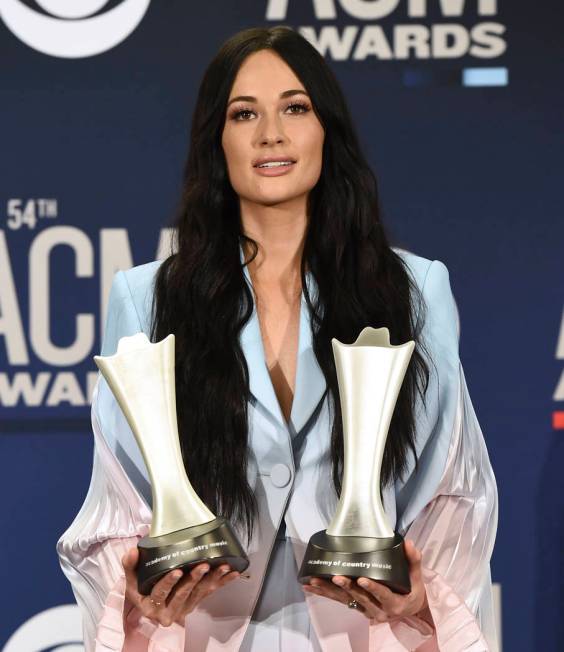 Kacey Musgraves poses in the press room with the awards for album of the year for "Golden ...