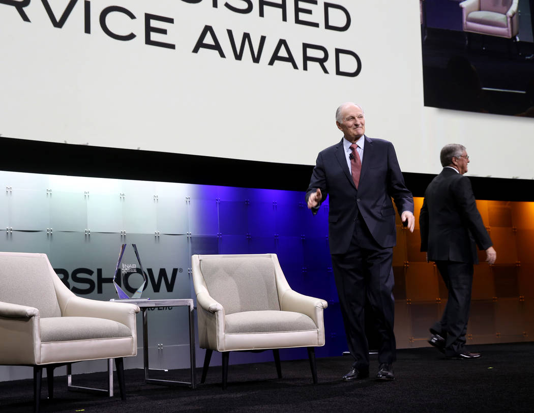Actor, director, screenwriter and podcaster Alan Alda, left, walks on stage to receive the Dist ...
