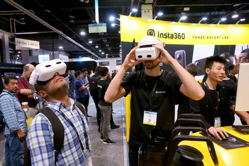 Eli MacKinnon, communications director at Insta360, right, shows Oscar Flores Solano of Mexico ...