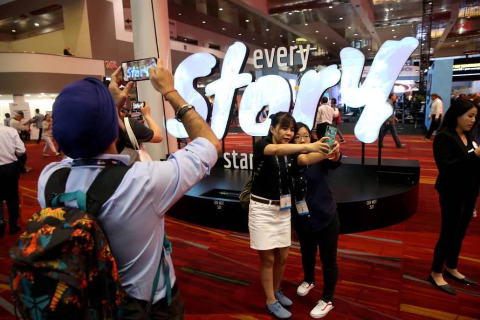 Kai Huang, left, and Gechun Xiao of China, take a selfie on the opening day of the National Ass ...