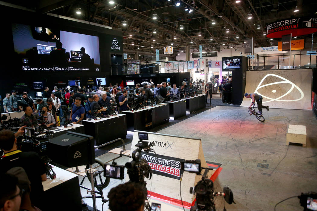 A professional BMX rider does tricks so conventioneers can check out camera monitors at the Ato ...