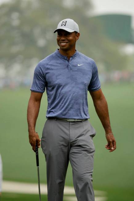 Tiger Woods smiles on the 10th green during a practice round for the Masters golf tournament Mo ...