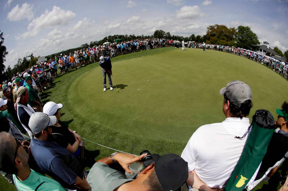 Tiger Woods putts on the practice green after a practice round for the Masters golf tournament ...