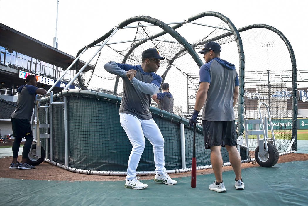 Retired Major League baseball player and now special coach Rickey Henderson, center, works with ...