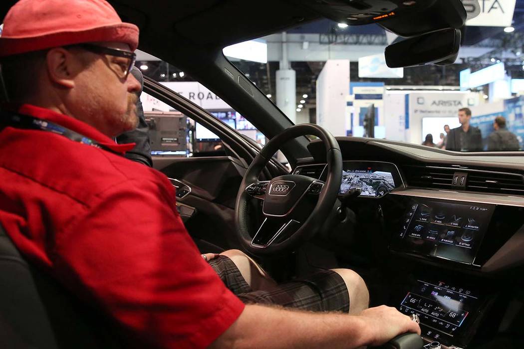 Kory Mortensen checks out digital dashboard display inside Audi e-tron during the National Asso ...