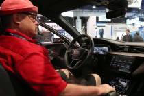 Kory Mortensen checks out digital dashboard display inside Audi e-tron during the National Asso ...